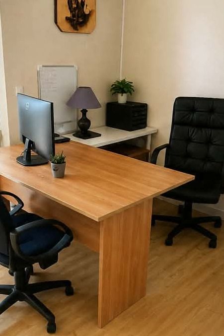 Le même bureau dégagé et nettoyé, avec seulement un écran et une plante, le sol propre et les sièges accessibles
