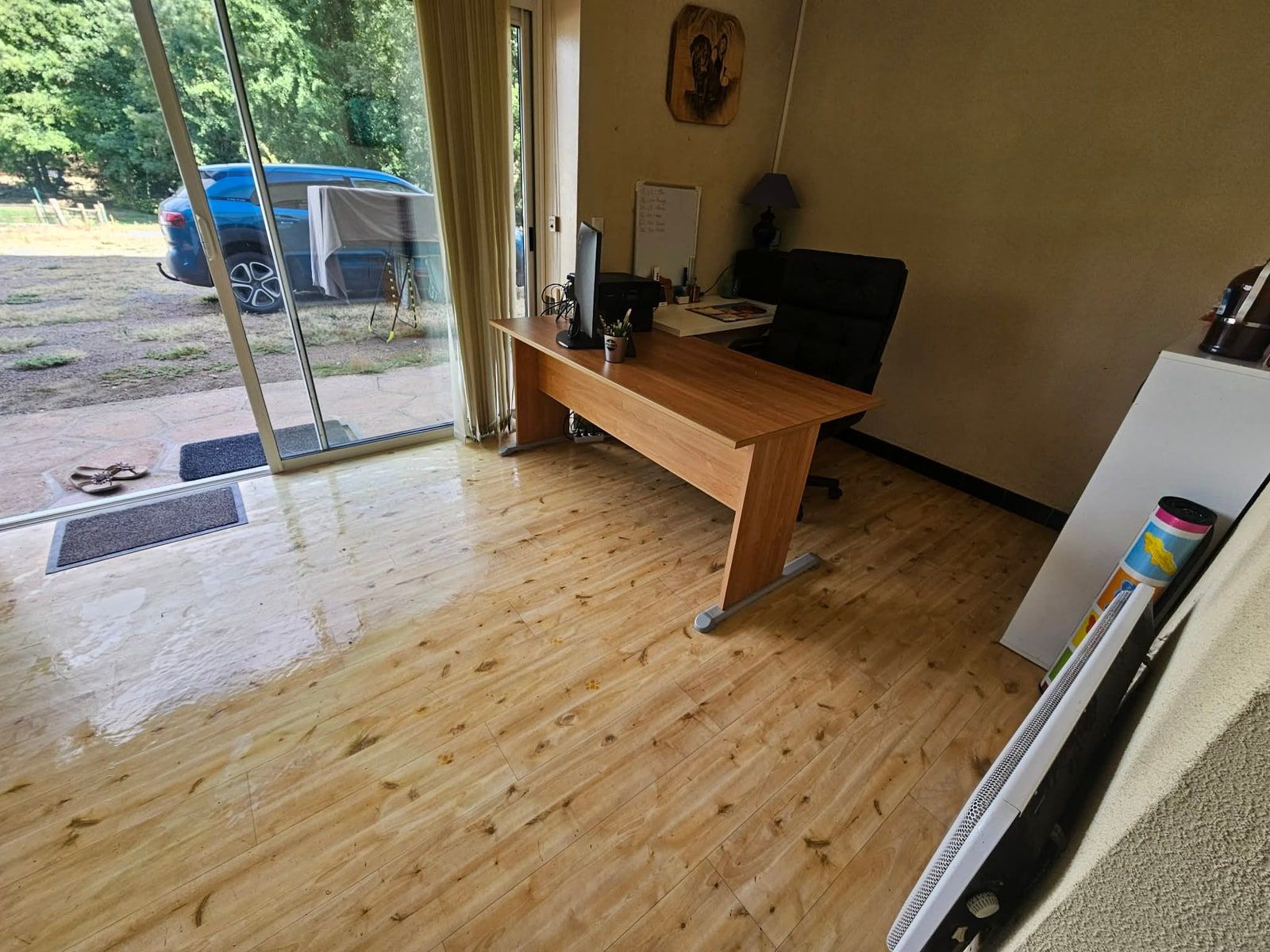 Le coin bureau dégagé, vu depuis la baie vitrée : plateau entièrement vide, sièges accessibles et parquet nettoyé